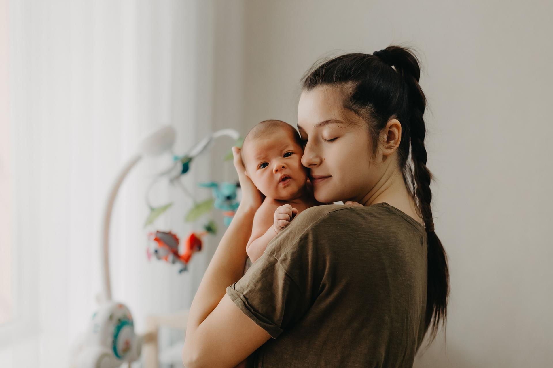 Tired young mom holds her one month old baby