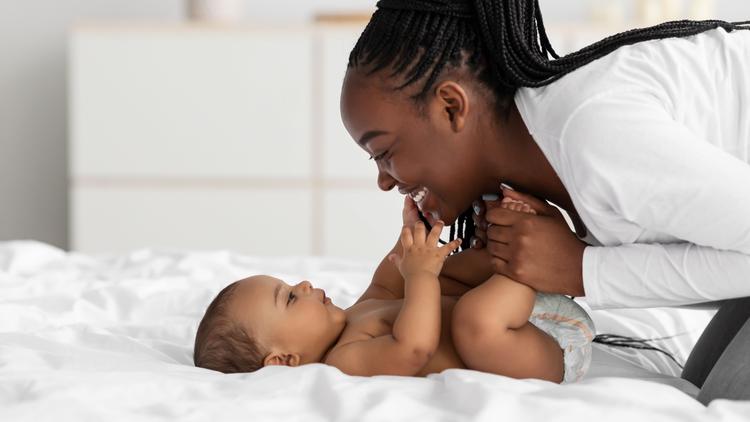 Young mom plays with her new baby